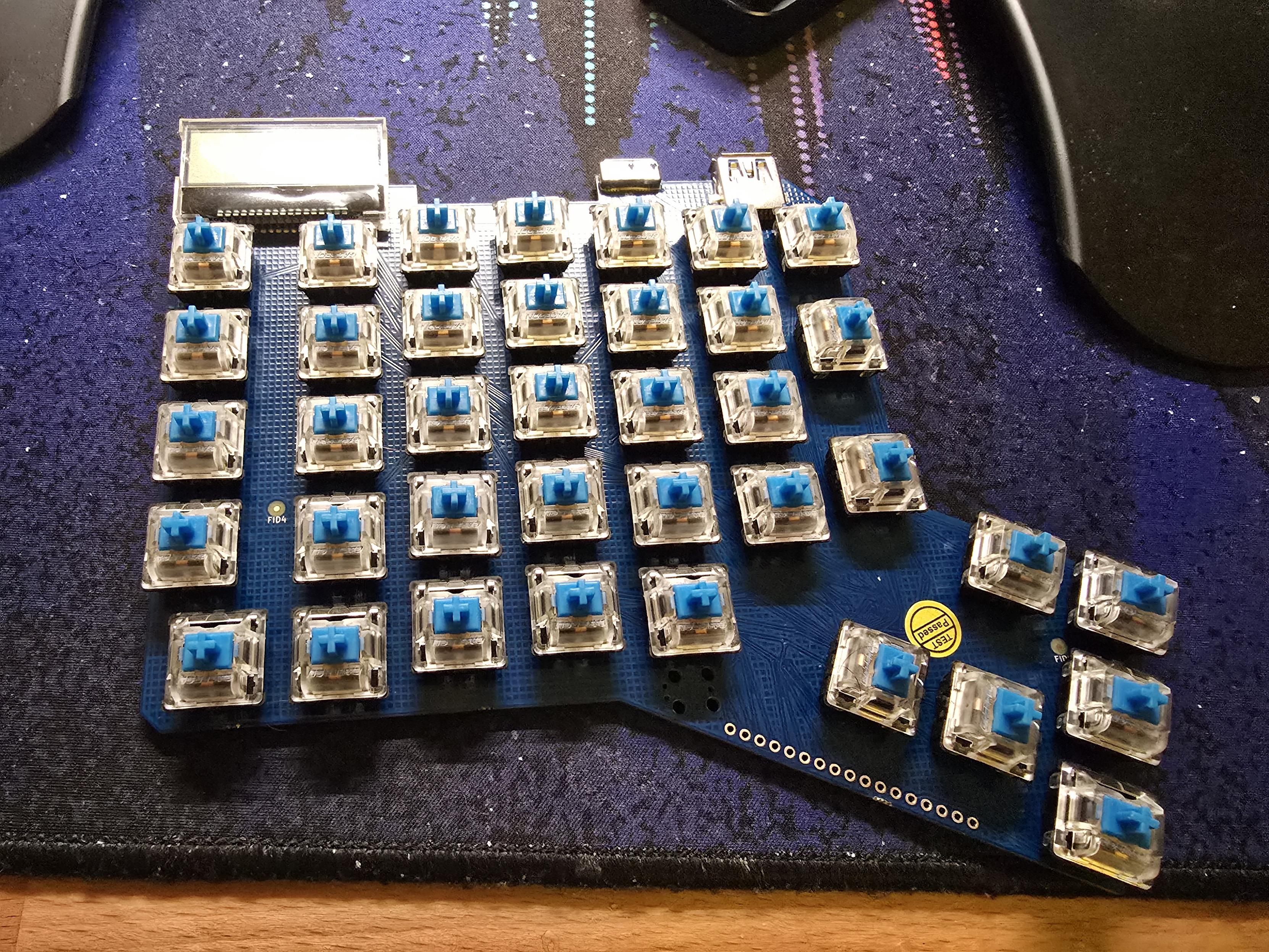 The left half of a split keyboard, as a bare circuit board with switches mounted on top